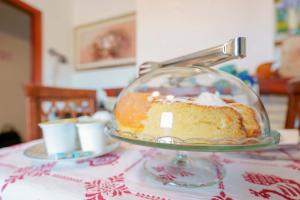 einen Kuchen in einem Glasgericht auf einem Tisch in der Unterkunft B&B Ametista in Villasimius