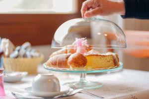 a person is reaching for a cake on a plate at B&B Ametista in Villasimius