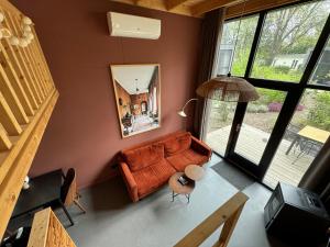 een woonkamer met een bank bij Tiny House Mayu - Veluwe Airco 4 persons in Arnhem