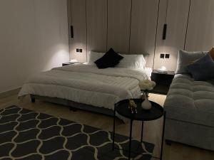 a bedroom with a bed and a couch at LUSSO Studio - استوديو لـوسـو الفندقي in Riyadh