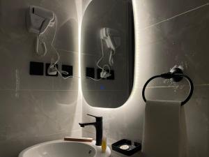 uma casa de banho com um lavatório e um espelho com um secador de cabelo em LUSSO Studio - استوديو لـوسـو الفندقي em Riade