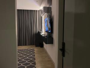 a hallway with a flat screen tv and a room with a television at LUSSO Studio - استوديو لـوسـو الفندقي in Riyadh