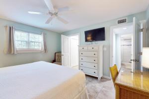 1 dormitorio con cama blanca y ventilador de techo en Seascape Golf Villas 6A en Destin