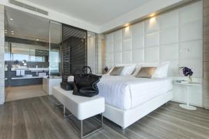 a bedroom with a large white bed and a chair at Almar Jesolo Resort & Spa in Lido di Jesolo
