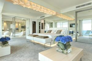 a bedroom with a white bed and a vase of flowers at Almar Jesolo Resort & Spa in Lido di Jesolo