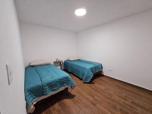 1 dormitorio con 2 camas y suelo de madera en Departamento Barrio Antiguo, en Monterrey