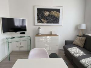 - un salon avec un canapé et une télévision dans l'établissement Appartement Balaruc-les-Bains, 2 pièces, 2 personnes - FR-1-553-183, à Balaruc-les-Bains