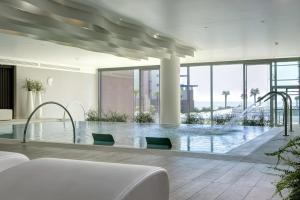 a pool in a building with glass walls at Almar Jesolo Resort & Spa in Lido di Jesolo