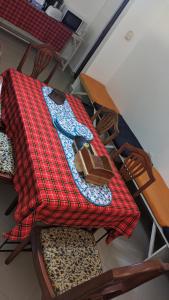 una mesa y sillas con una manta encima en JACARANDA HOMESTAY en Moshi