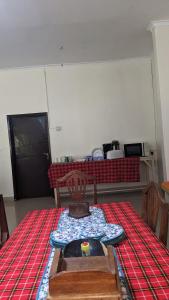 Habitación con mesa y manta roja y blanca en JACARANDA HOMESTAY en Moshi
