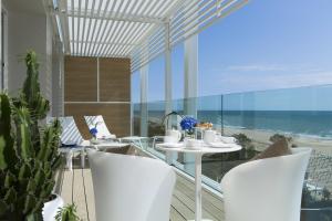 a balcony with a table and chairs and the ocean at Almar Jesolo Resort & Spa in Lido di Jesolo