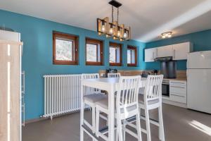 - une cuisine avec des murs bleus, une table et des chaises blanches dans l'établissement Villa Grenadine House Furnished, à Sévrier
