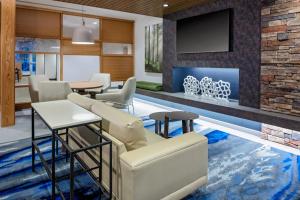 sala de estar con sofá, sillas y TV en Fairfield Inn & Suites by Marriott Memphis Collierville, en Collierville