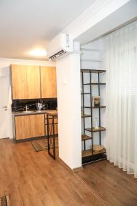 プリシュティナにあるArt Apartmentの白い壁のキッチン(木製キャビネット付)