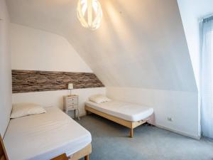 a small bedroom with two beds and a lamp at Maison Estarvielle, 5 pièces, 10 personnes - FR-1-695-25 