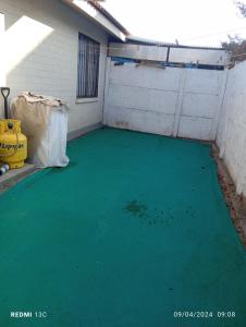 a garage with a green floor in front of a building at Hostal JV QUILLOTA AMOBLADA in Quillota