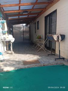 d'une terrasse avec un barbecue, une table et un sol vert. dans l'établissement Alojamiento jv QUILLOTA AMOBLADA, à Quillota
