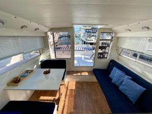 uma sala de estar com um sofá azul e uma mesa em Barco amplio con 2 camarotes / Comfy Boat with 2 bedrooms - Barcelona em Barcelona