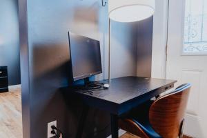 einen Schreibtisch mit einem Computermonitor und einem Stuhl in der Unterkunft Urban Studio WFH Setup & Patio Soulard in Soulard