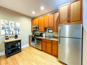 a kitchen with wooden cabinets and a stainless steel refrigerator at Modern 1BR-1BA Monthly Rental The Hill in Tower Grove
