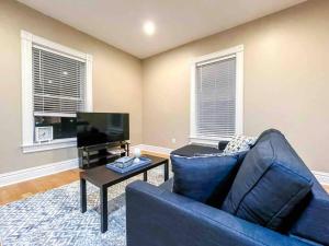 a living room with a blue couch and a tv at Modern 1BR-1BA Monthly Rental The Hill in Tower Grove