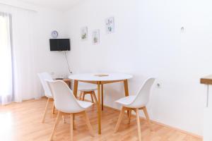 una sala da pranzo con tavolo e sedie bianche di Apartmani Zvirac a Soko Banja