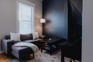 a living room with a couch and a tv at Chic 1BR Balcony & Laundry Soulard in Soulard