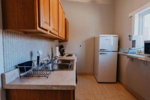 a kitchen with a sink and a refrigerator at Chic 1BR Balcony & Laundry Soulard in Soulard