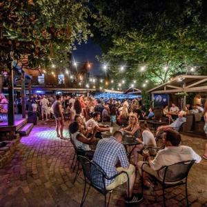 a crowd of people sitting at tables at an outdoor event at Chic 1BR Balcony & Laundry Soulard in Soulard