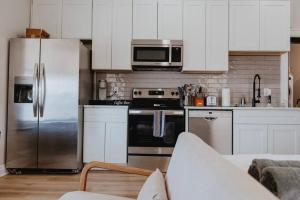 a kitchen with stainless steel appliances and white cabinets at Chic Studio Walk to SMM SLU Hospital Grand in Tower Grove