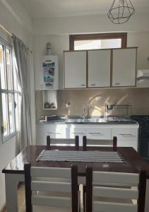 a kitchen with a table and a kitchen with a sink at Morada Las Caléndulas in Ushuaia +3 photos