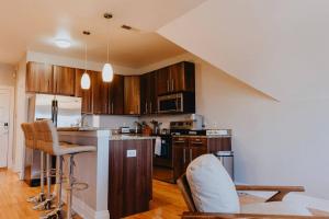 a kitchen with wooden cabinets and a counter top at Modern 1BR-1BA Walk to SSM SLU Hospital Grand in Tower Grove