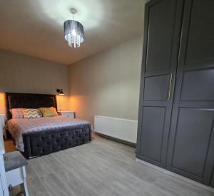 1 dormitorio con 1 cama y armario grande en Cara's Cottage, en Kinawley