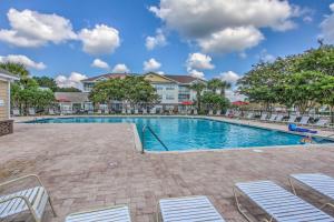 a swimming pool with chairs and a building at North Myrtle Beach Condo Rental with Pool Access! in North Myrtle Beach