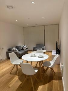 ein Wohnzimmer mit einem weißen Tisch und Stühlen in der Unterkunft Simply lux apartment in London