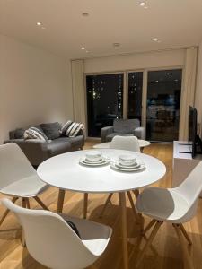 ein Wohnzimmer mit einem weißen Tisch und Stühlen in der Unterkunft Simply lux apartment in London