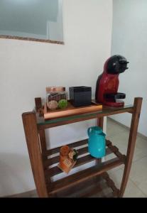 uma pequena mesa de madeira com comodidades para preparar café em Casa Charmosa em Taubaté