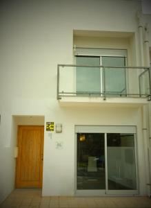 a balcony on the side of a building with a door at Guest House De Fajã Ponta Delgada in Ponta Delgada