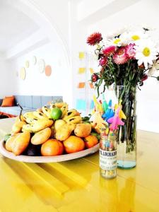 un piatto di frutta su un tavolo con un vaso di fiori di Casa colonial en el centro de San Cristobal de las casas a San Cristóbal de Las Casas