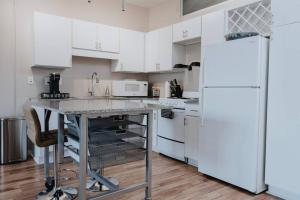 a kitchen with white cabinets and a white refrigerator at Cozy Studio w Pool & WFH Setup St Louis in Tower Grove