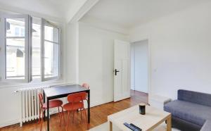 a living room with a table and a couch at Appartement, cœur des Batignolles Montmartre in Paris