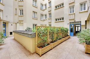 een rij planten in een tuin voor een gebouw bij Appartement, cœur des Batignolles Montmartre in Parijs