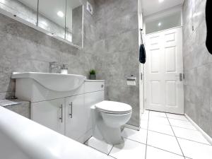 a bathroom with a white toilet and a sink at Contemporary and Cosy Birmingham Apartment- Free Parking & Wi-FI in Birmingham