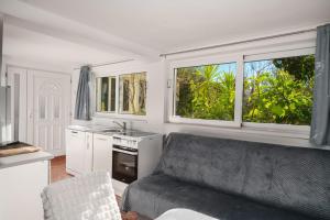 un soggiorno con un divano e due finestre di Studio Apartman Vodice a Vodice