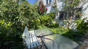 un tavolo di vetro e una panca in un giardino di Studio Apartman Vodice a Vodice