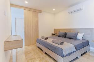 - une chambre avec un grand lit et une tête de lit en bois dans l'établissement Torre Diez Grupo Amber - Collection O, à Playa del Carmen