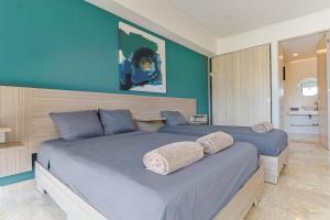 - une chambre avec 2 lits aux murs bleus dans l'établissement Torre Diez Grupo Amber - Collection O, à Playa del Carmen