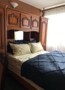 - un lit avec une tête de lit en bois dans une chambre dans l'établissement Private room near Metro 5 Bobigny, à Bobigny