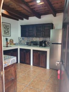 a kitchen with wooden cabinets and a stainless steel refrigerator at 2 Pilas: historic colonial house in Antigua Guatemala
