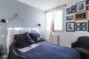 1 dormitorio con 1 cama con manta azul en modern apartment Sacré-coeur en París